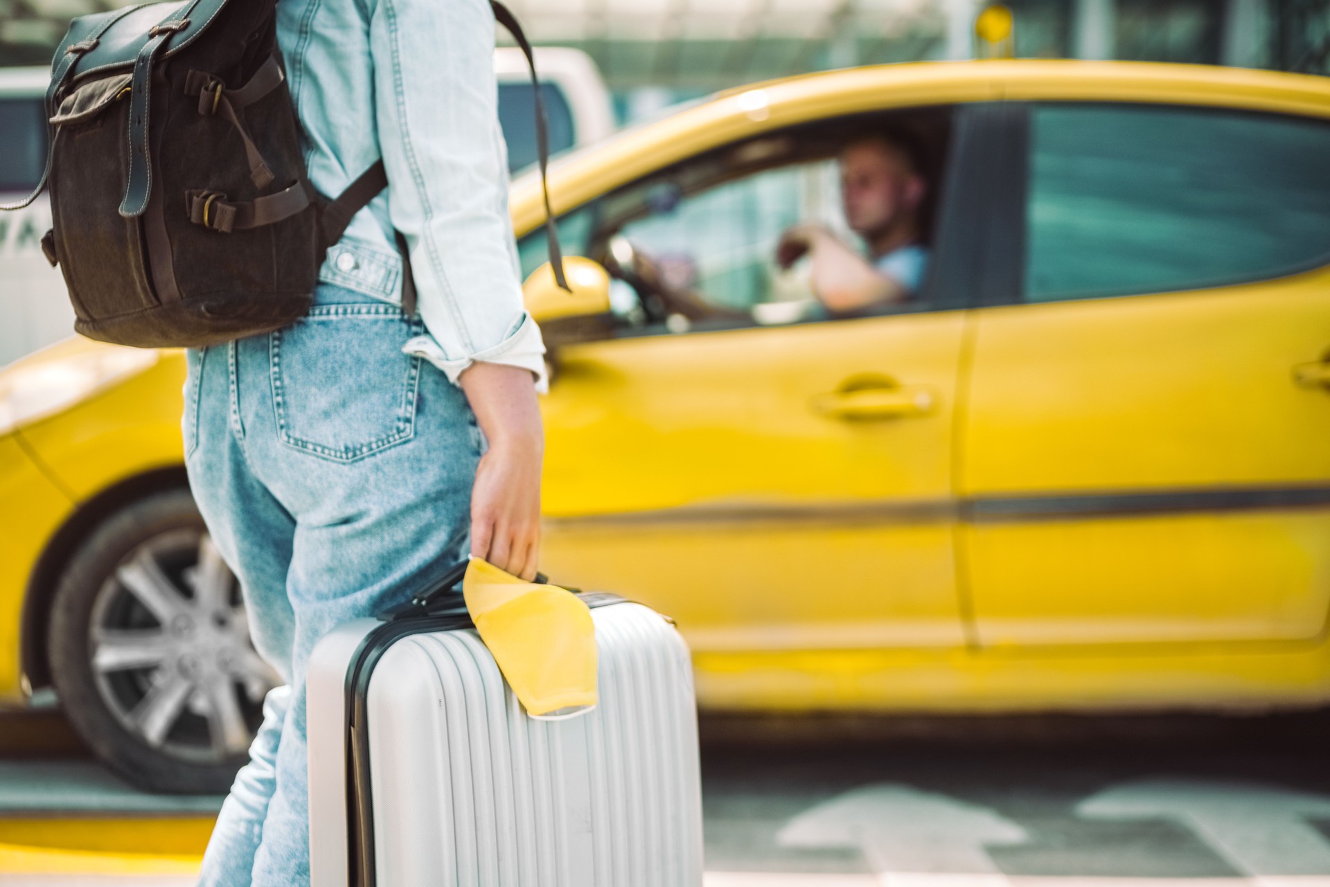 Woman waiting for taxi with face mask and travel case